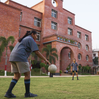 Energetic girls from MBIS participating in a competitive handball game.